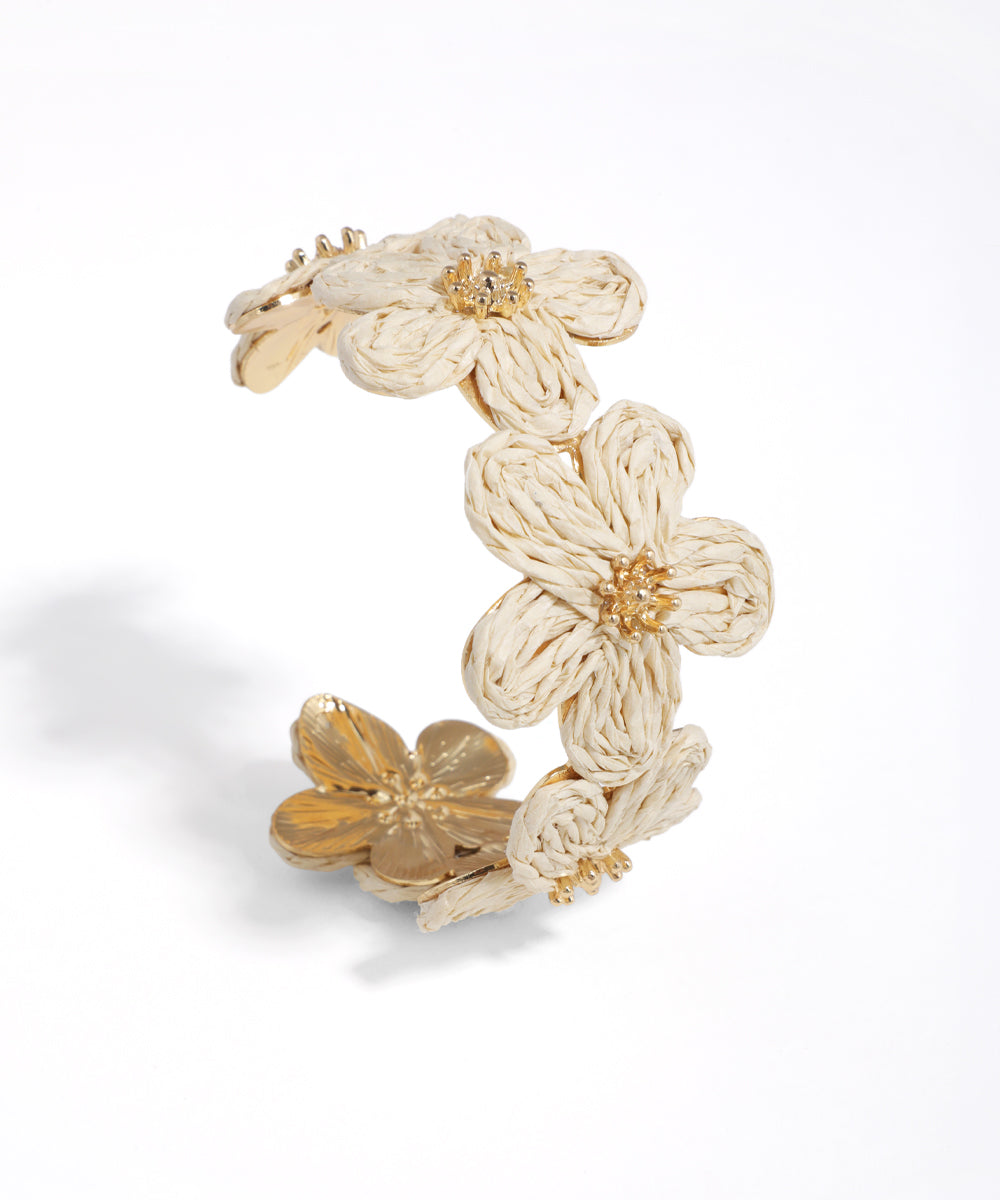 Gold-tone bangle bracelet with woven and metallic floral details