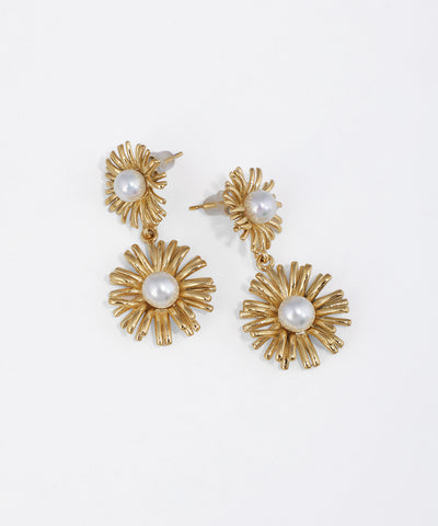 Gold-tone drop earrings with textured floral sunburst design and central faux pearls on white background.
