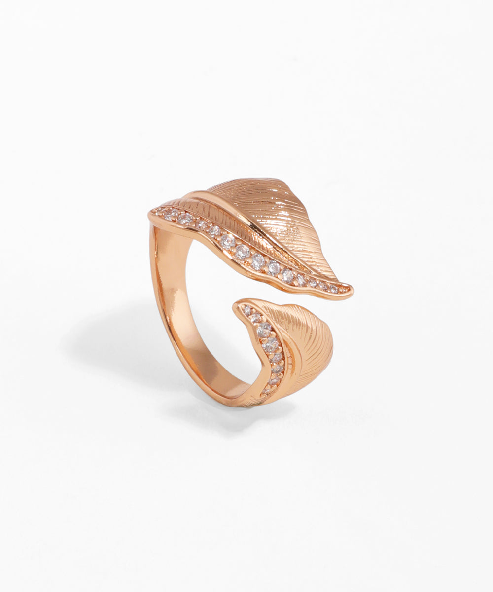 Rose-gold-tone ring with textured leaf design and clear cubic zirconia stones