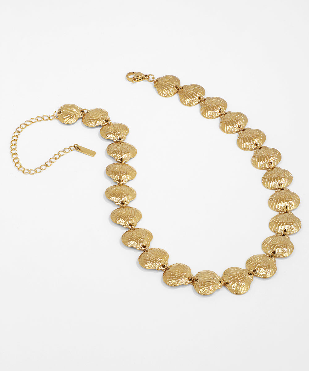 Gold necklace with textured beads on a white background