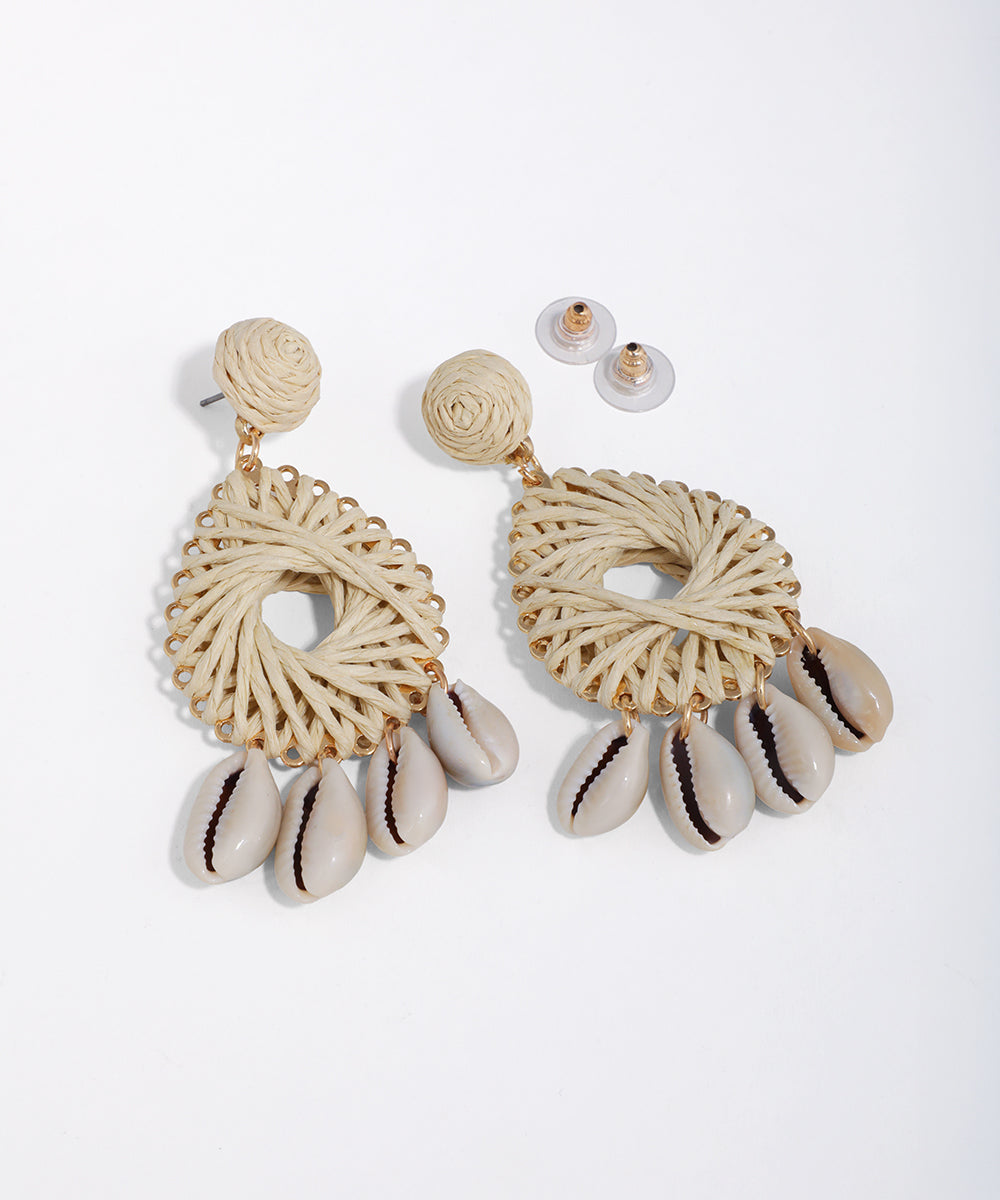 Gold-tone drop earrings with natural woven texture and dangling cowrie shells