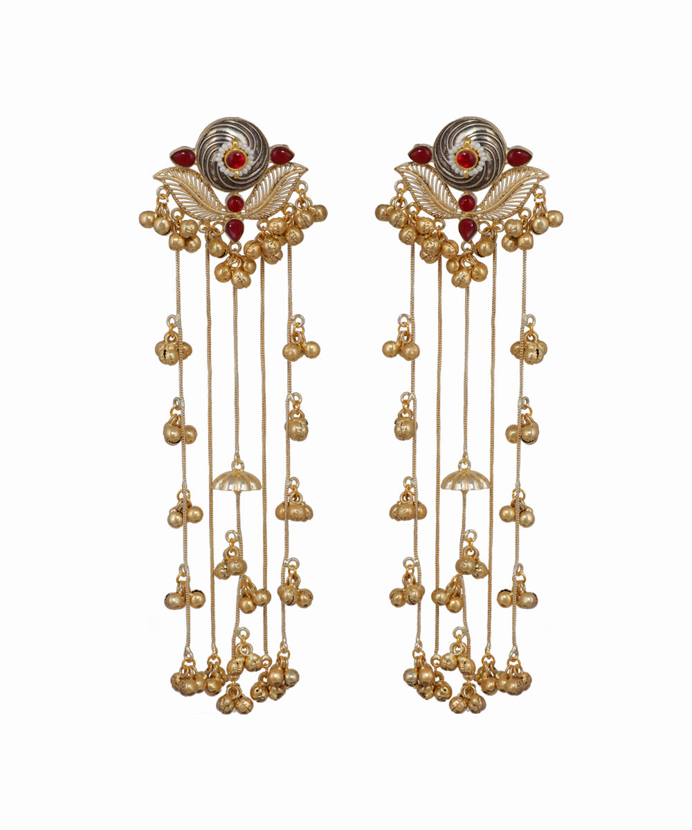 Pair of gold earrings with red gemstones on a white background