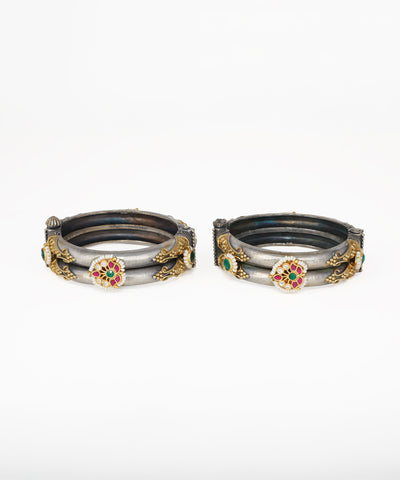 Oxidised silver-tone bangle bracelets with gold-tone accents, red and green stones, and faux pearls