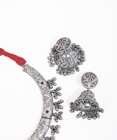 Silver jewelry set with earrings and a necklace on a white background