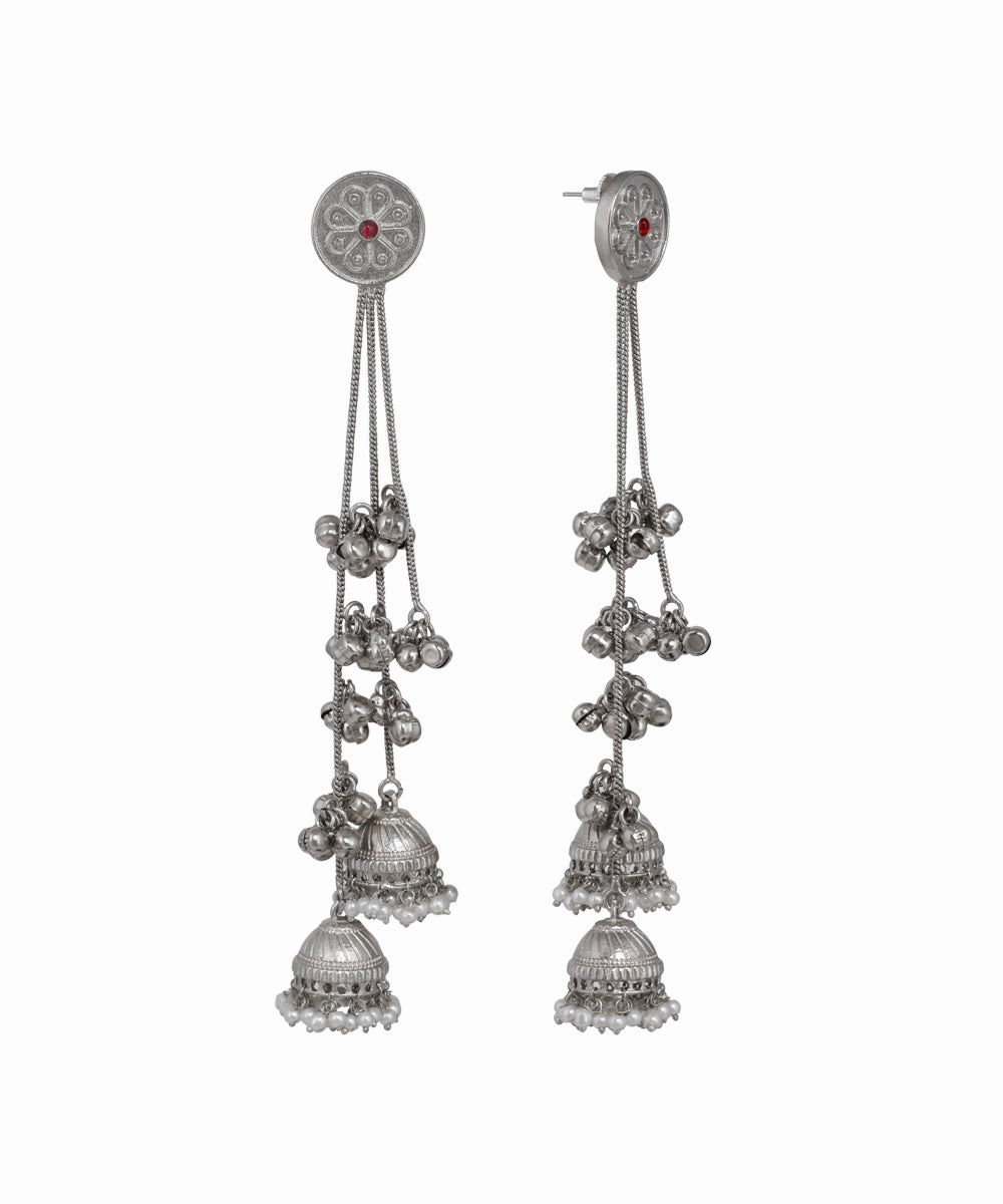 Pair of silver earrings with dangling components on a white background