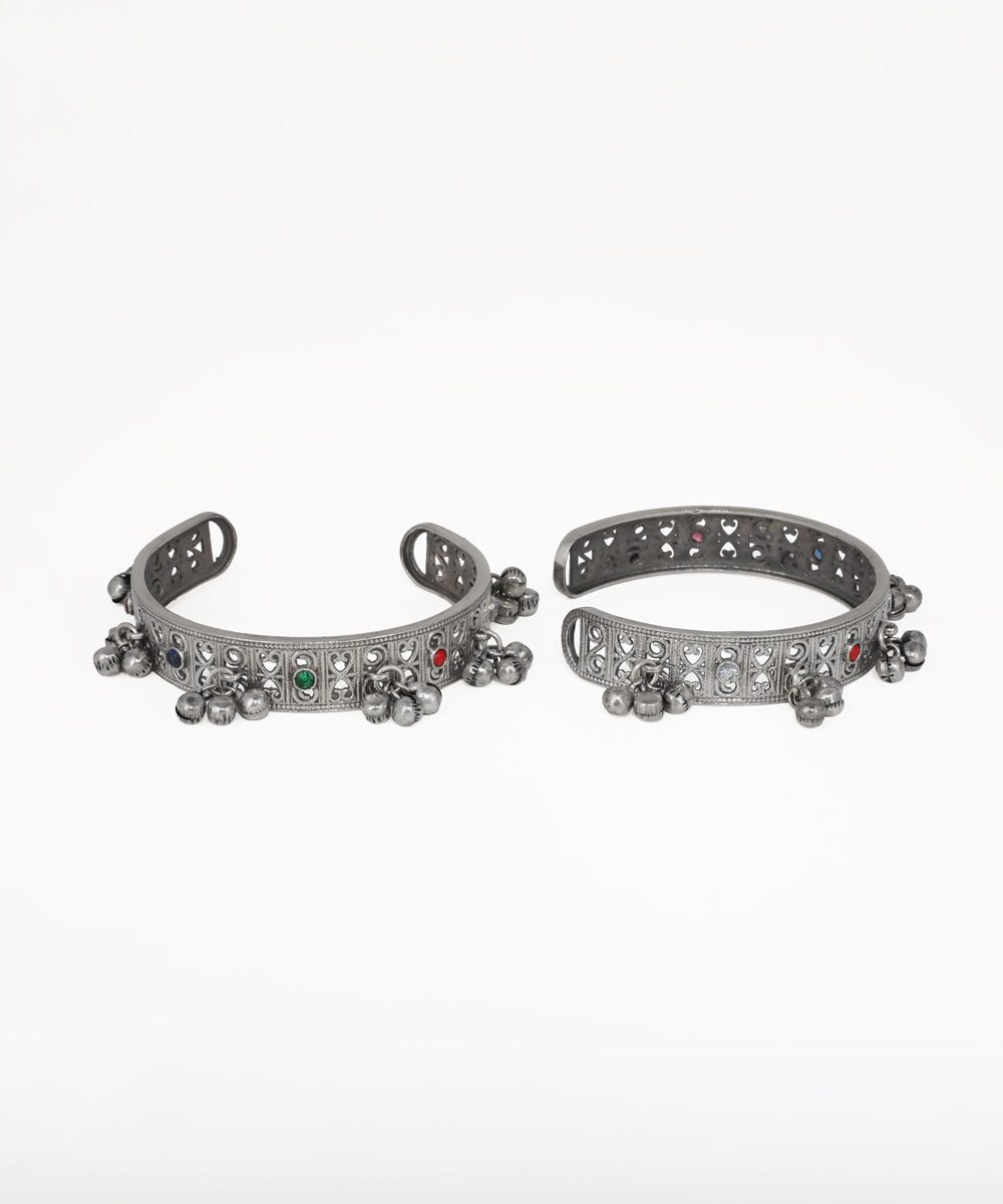 Pair of silver anklets with decorative elements on a white background