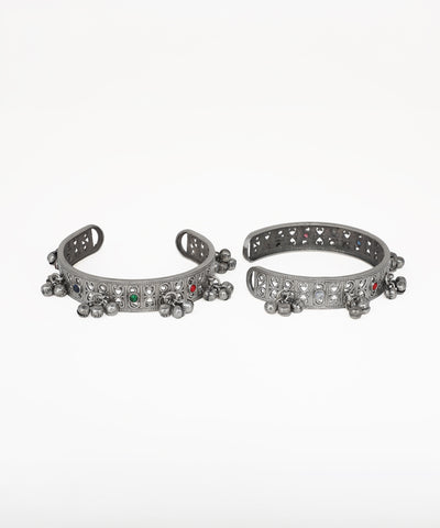 Pair of silver anklets with decorative elements on a white background