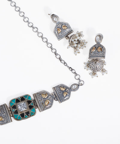 Silver bracelet with decorative clasp and earrings on a white background