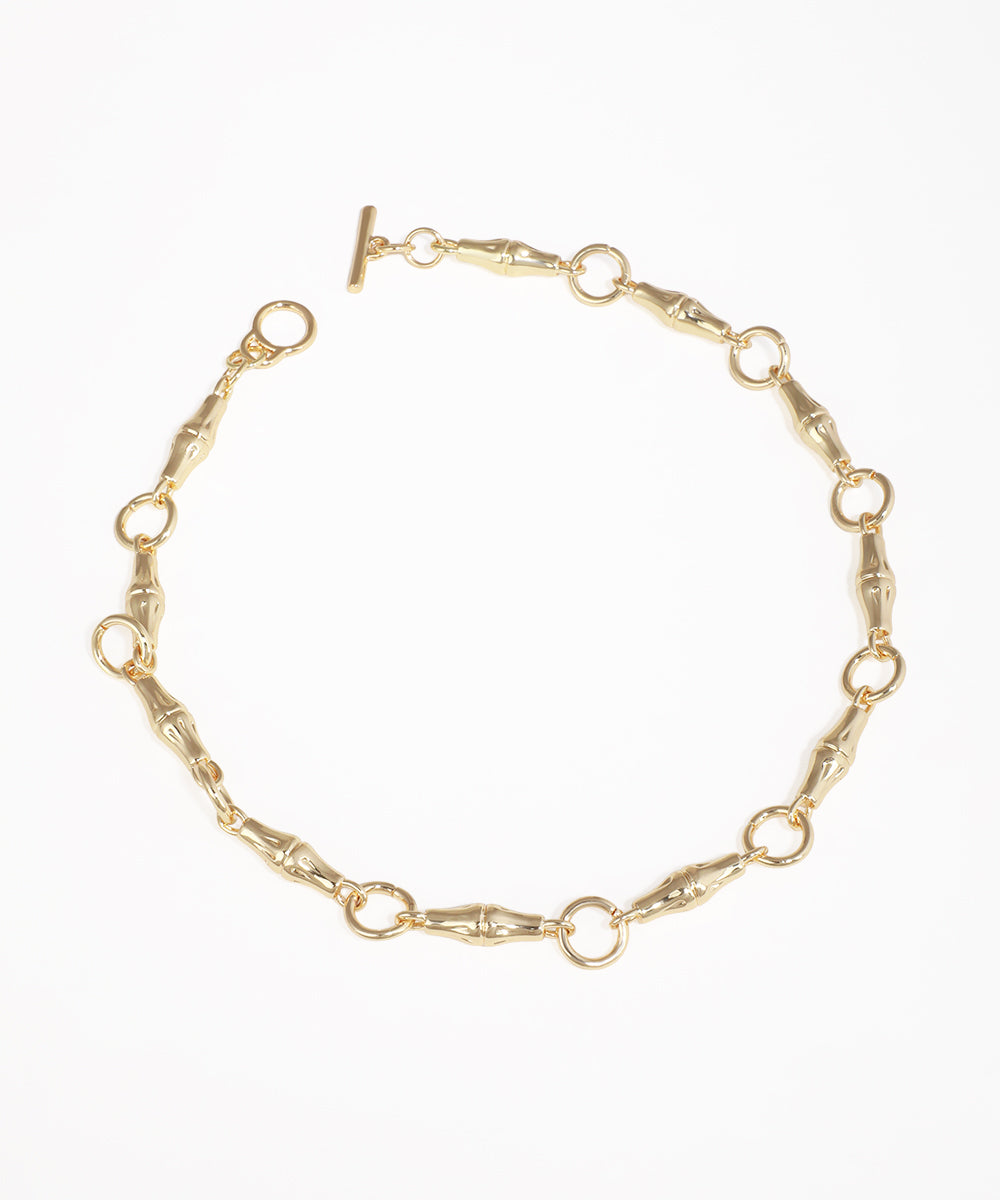 Gold-tone necklace with chunky bamboo-shaped links and a front toggle closure