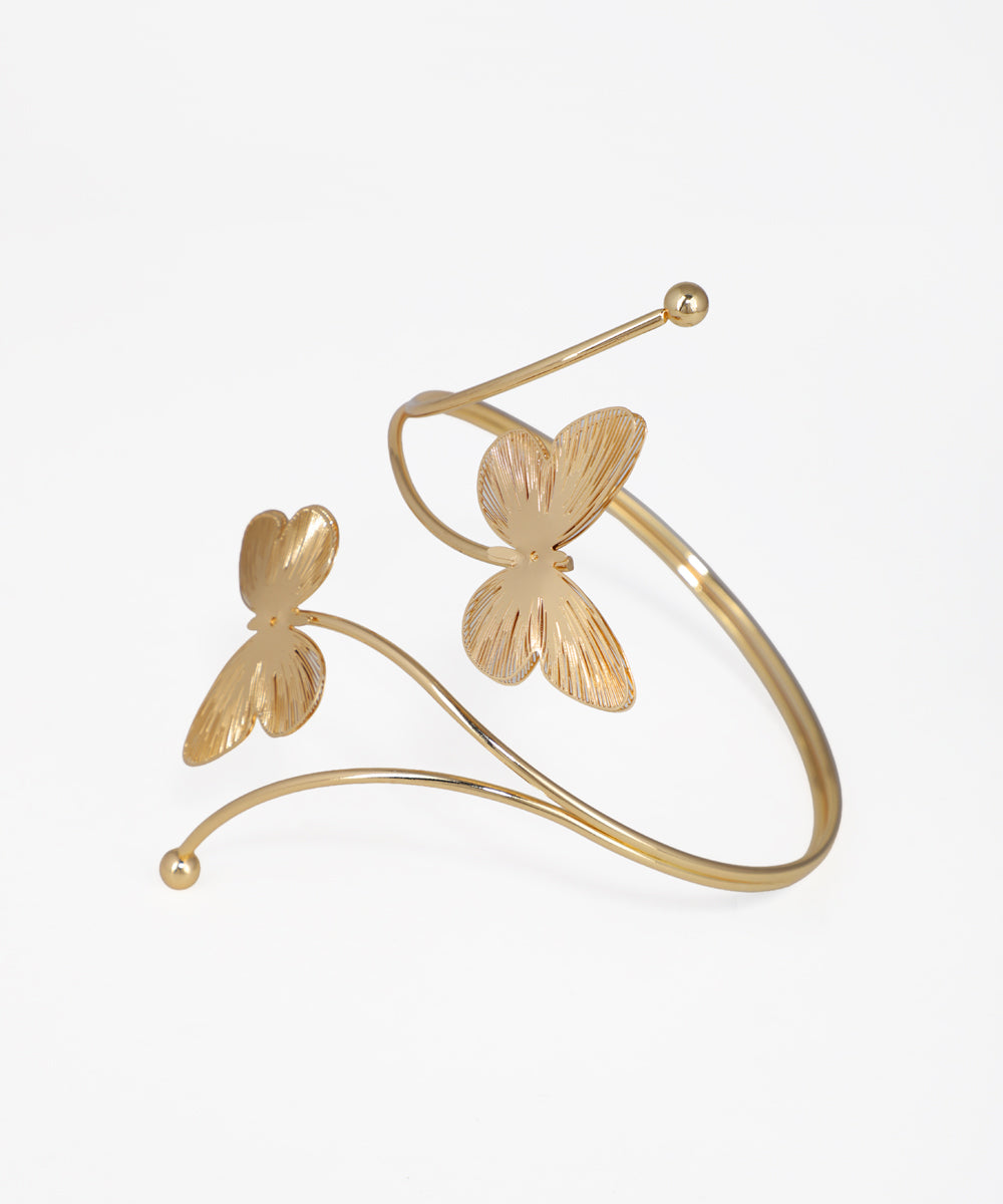 Gold butterfly-shaped cuff bracelet on a white background