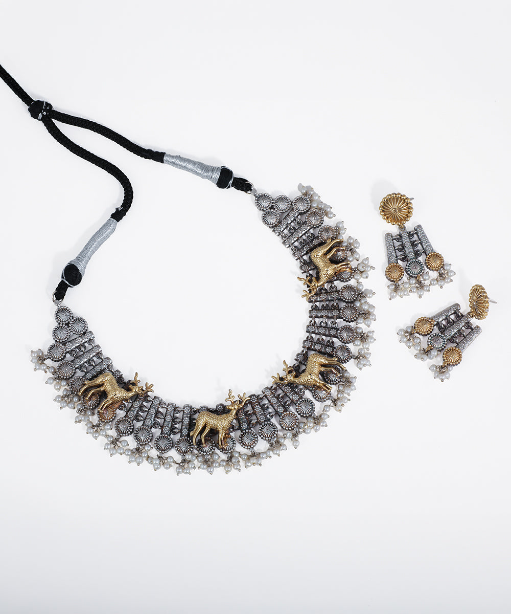 Oxidized silver-tone necklace set with gold-tone deer motifs and faux pearl drops on a white background.