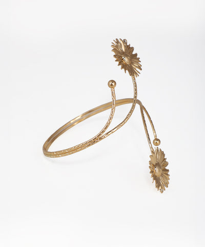 Gold bracelet with floral designs on a white background