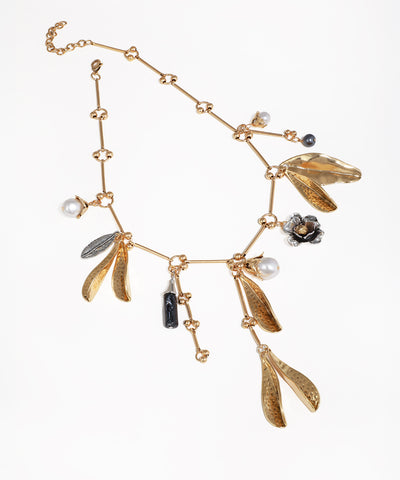 Gold-tone necklace with textured leaf drops, faux pearls, dark flower, and feather charms.