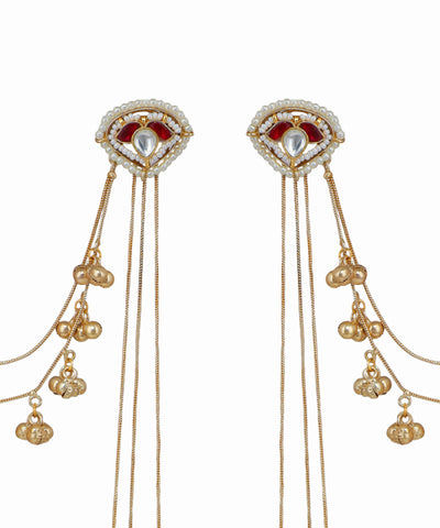 Pair of gold earrings with red gemstones and dangling beads on a white background