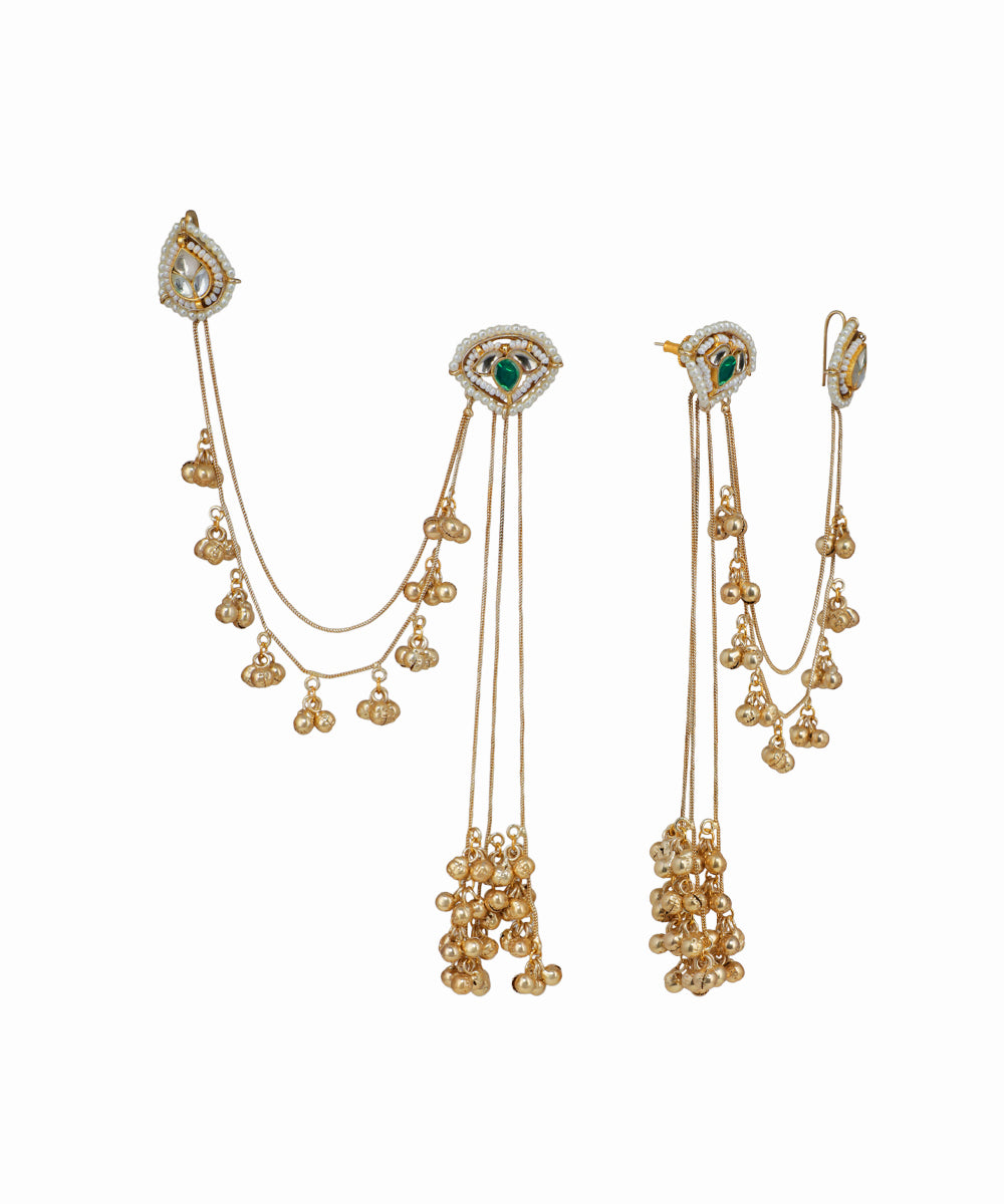 Gold earrings with green gemstones on a white background