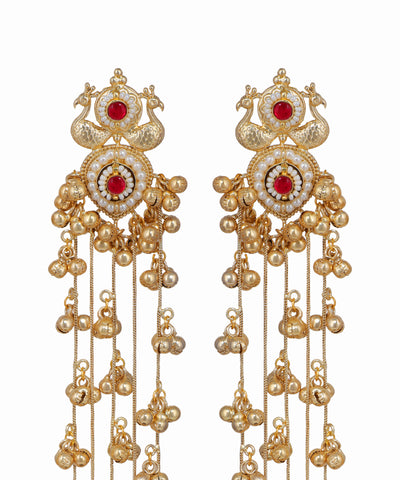 Ornate gold earrings with red gemstones on a white background