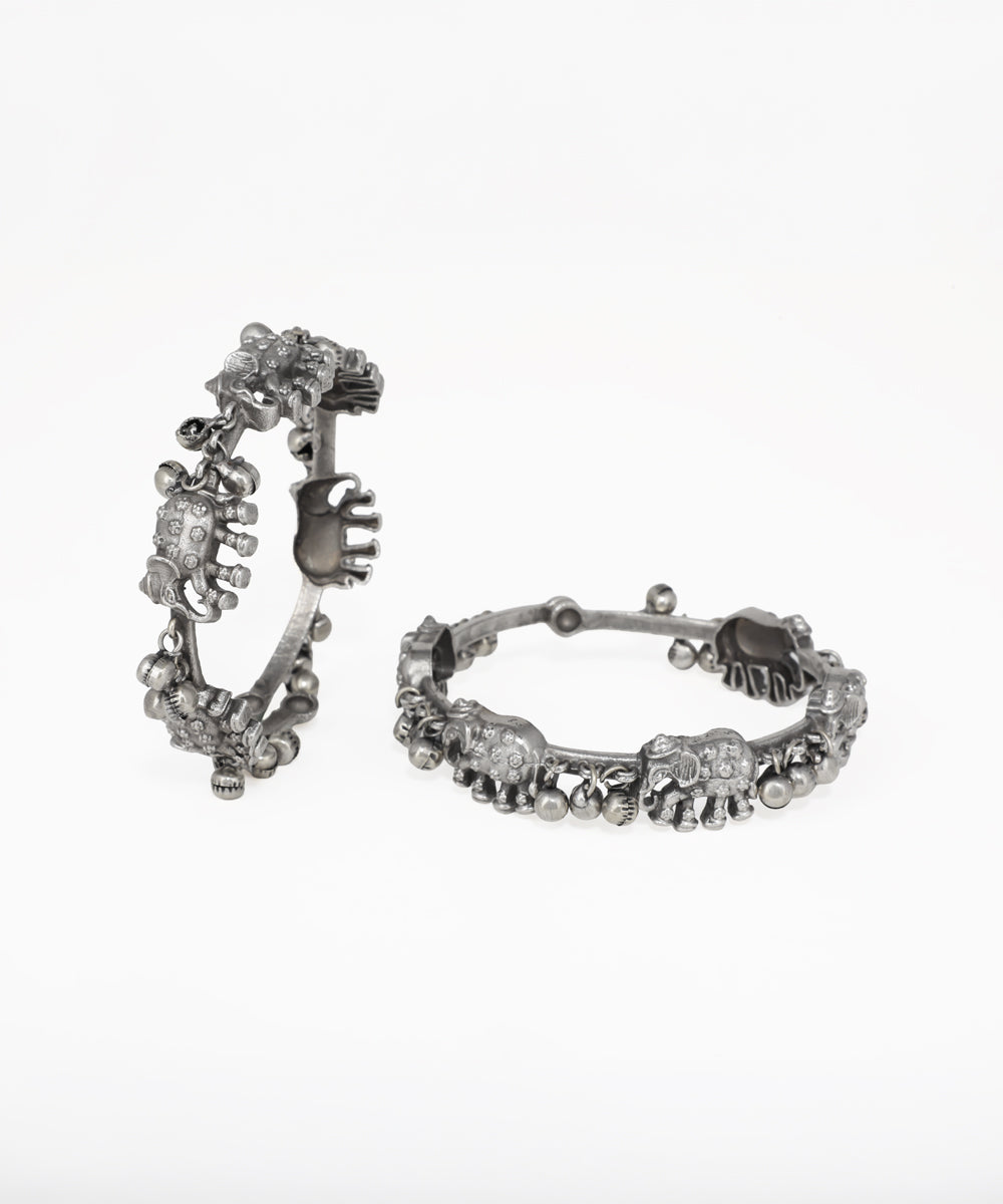 Pair of silver hoop earrings with floral and leaf designs on a white background