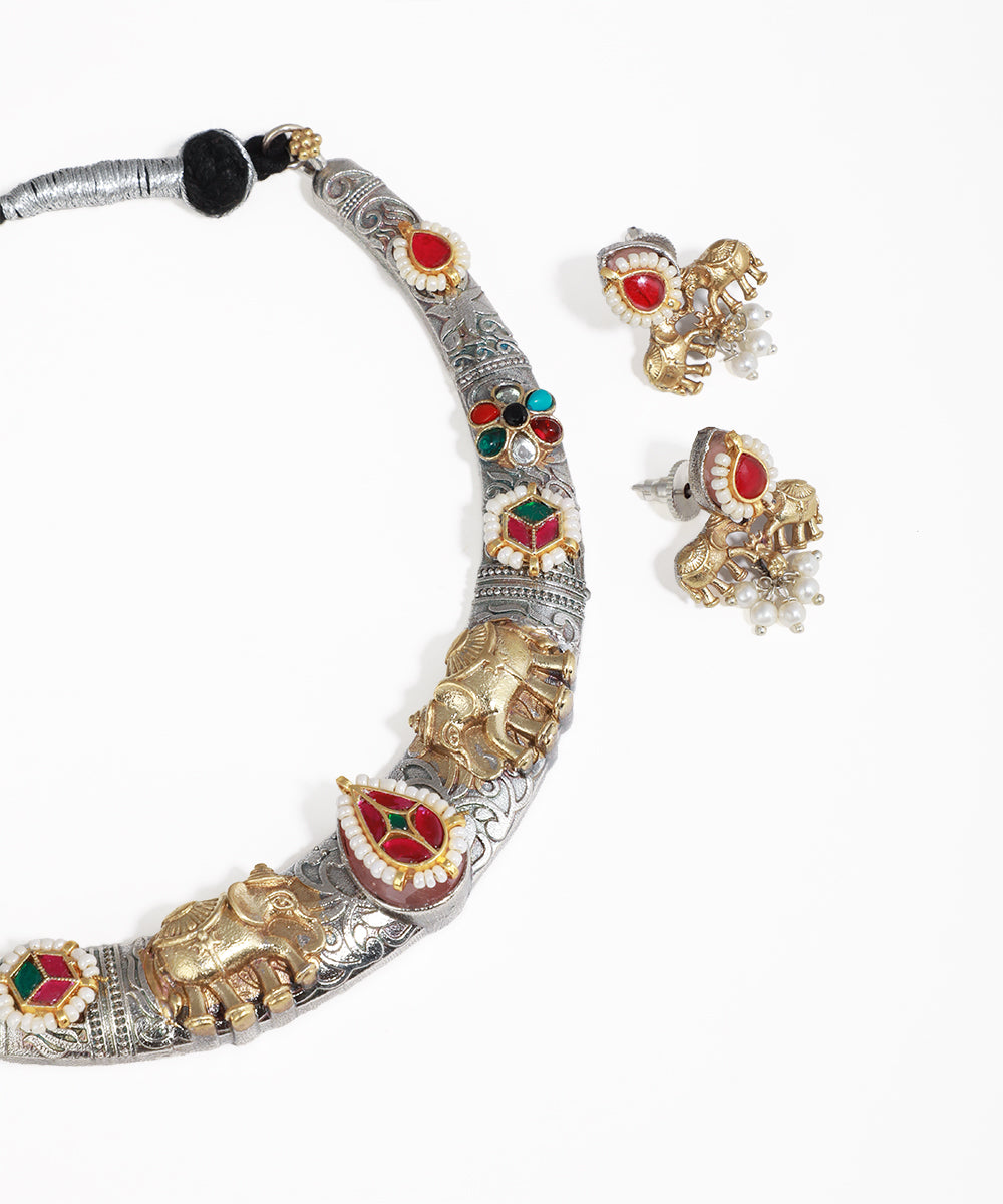 Ornate necklace with elephant designs and matching earrings on a white background