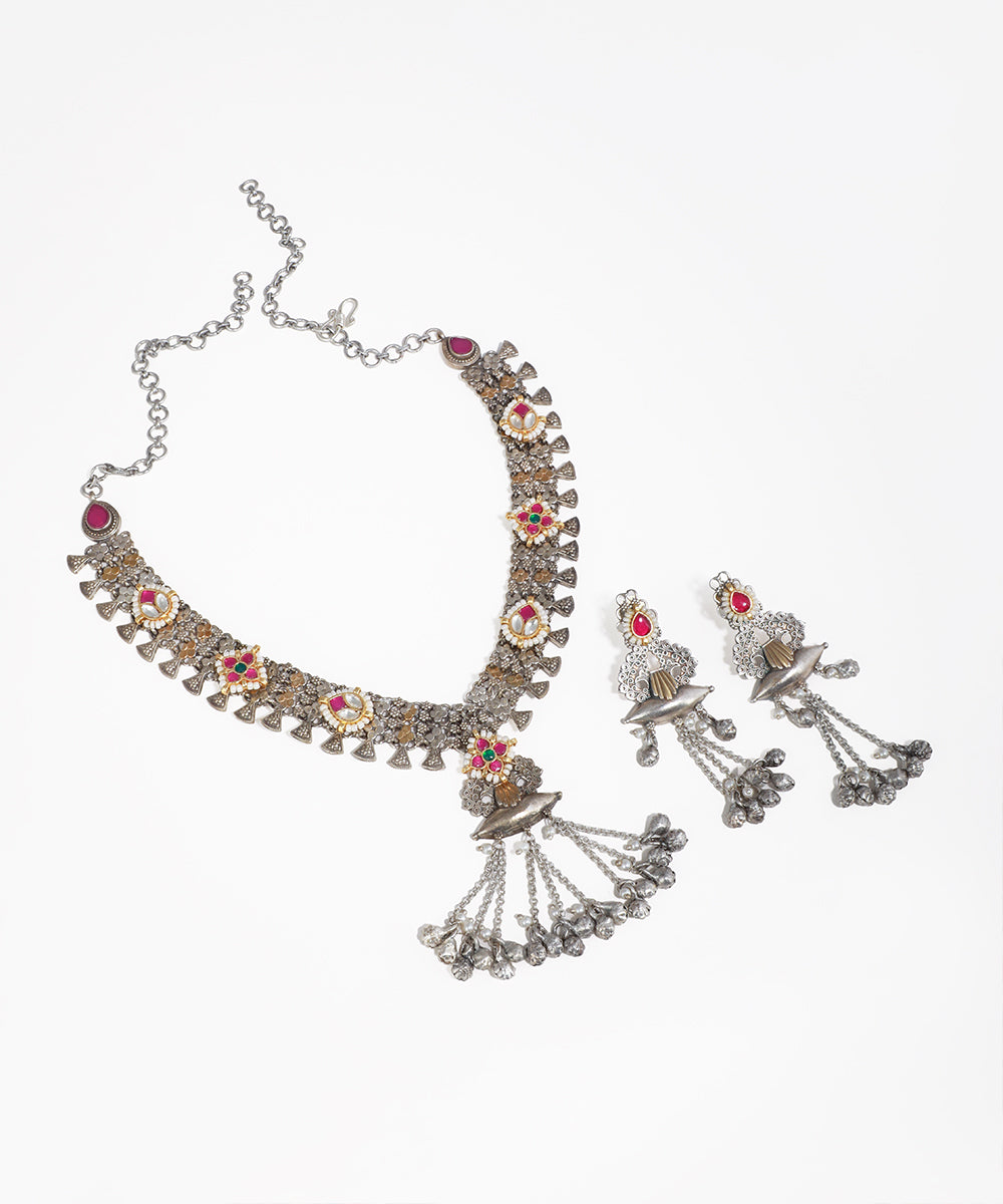 Oxidised silver-tone necklace set with floral motifs, colored stones, faux pearls, and ghungroo drops.
