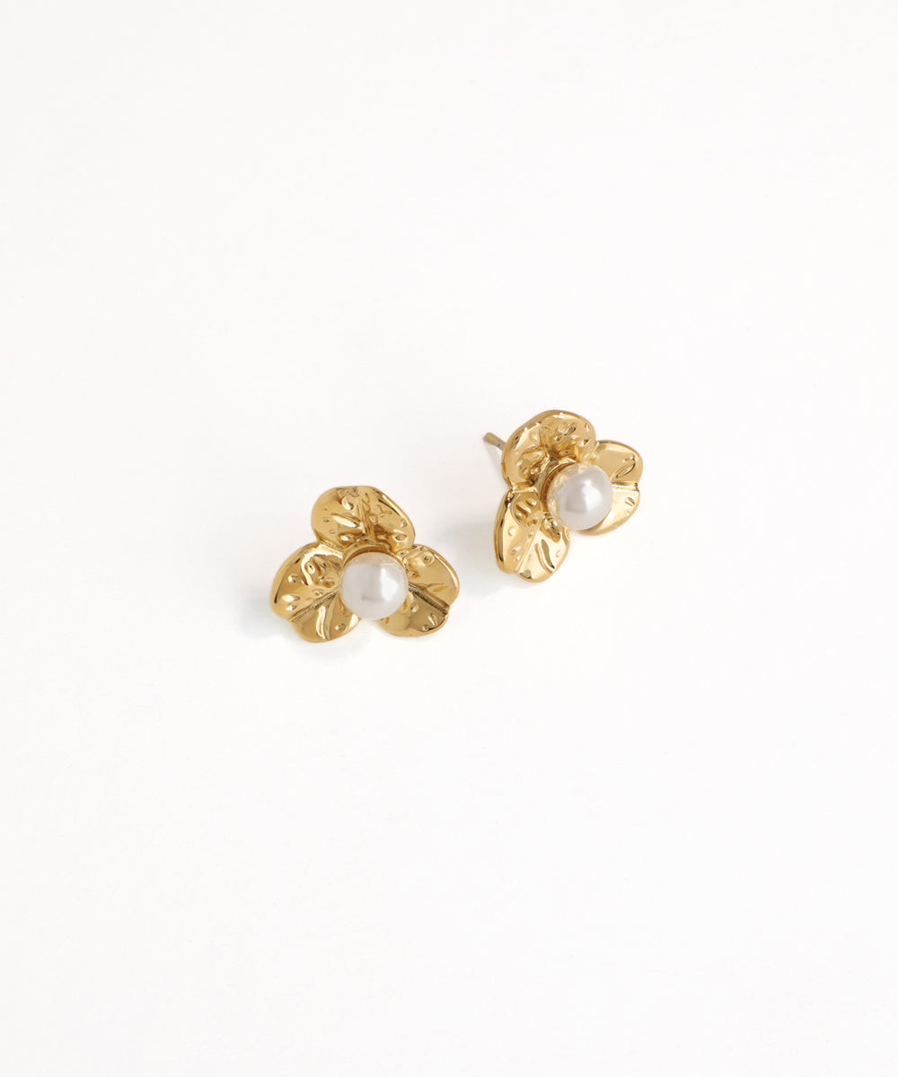 Gold earrings with pearl centers on a white background
