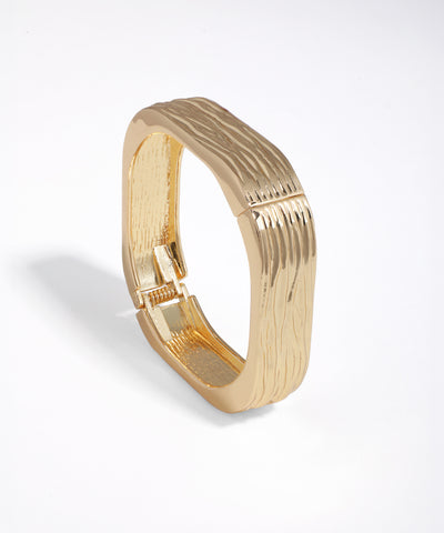 Gold-tone bangle bracelet with wavy textured surface and square profile