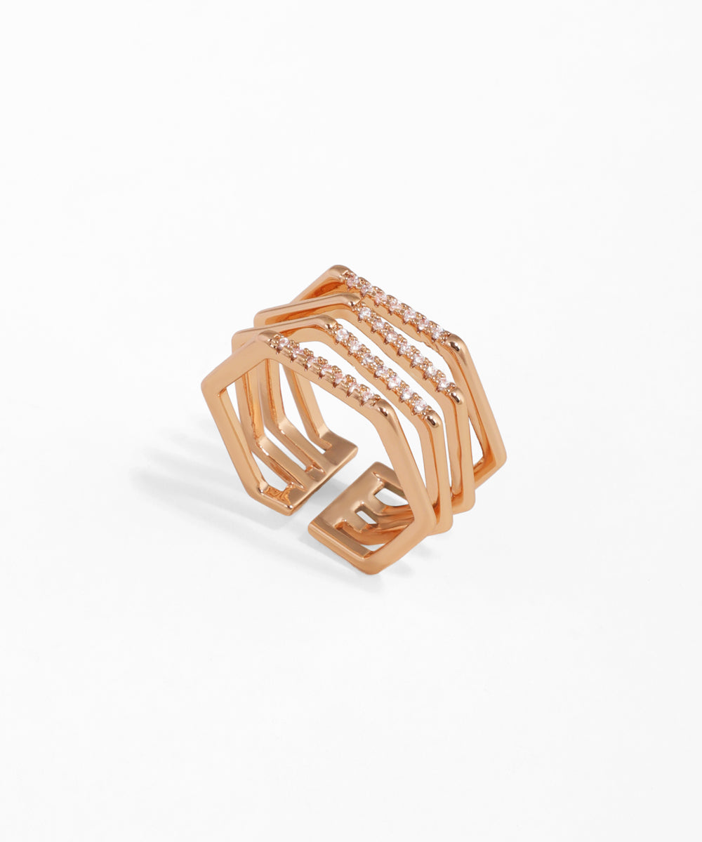 Rose gold geometric ring with embedded stones on a white background