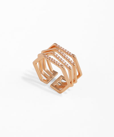 Rose gold geometric ring with embedded stones on a white background