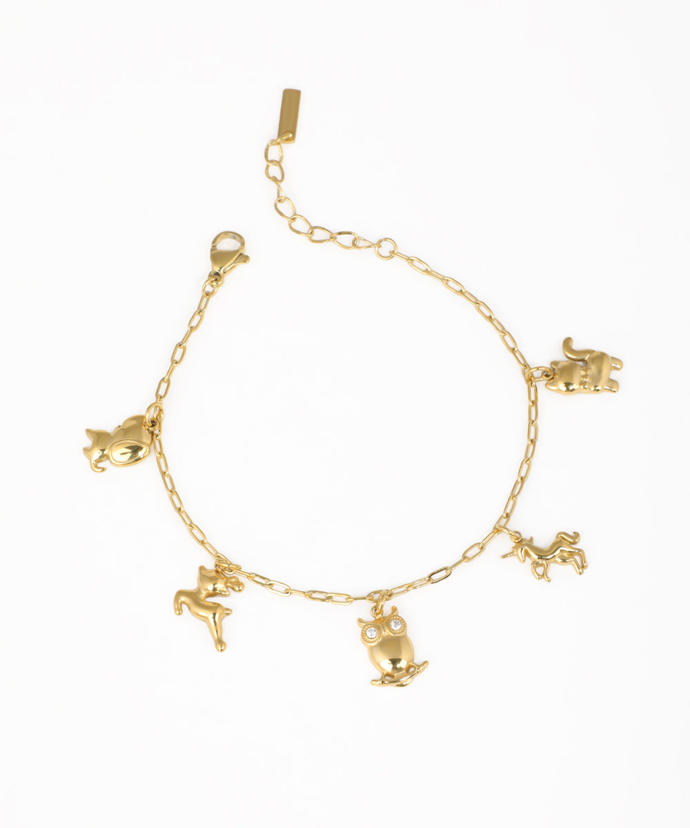 Gold-tone charm bracelet with various animal figures, including an owl with clear stones and a unicorn.