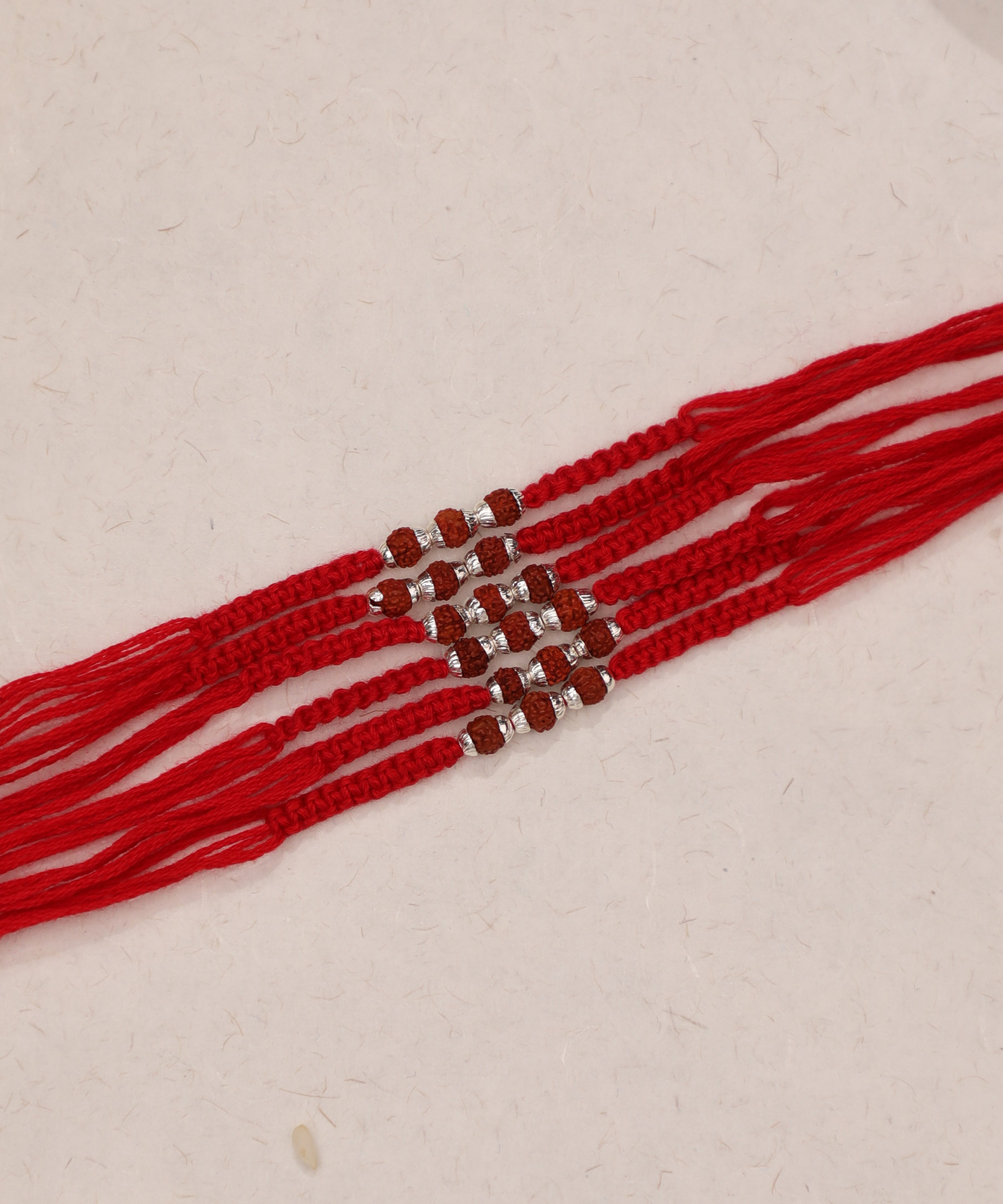 Red thread Rakhi set with brown Rudraksha and silver-tone beads
