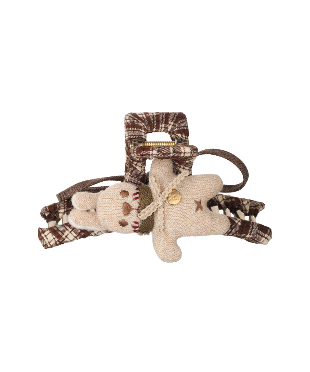 Brown plaid fabric claw clip with an attached beige knitted bear charm and a small gold-tone hand-made tag