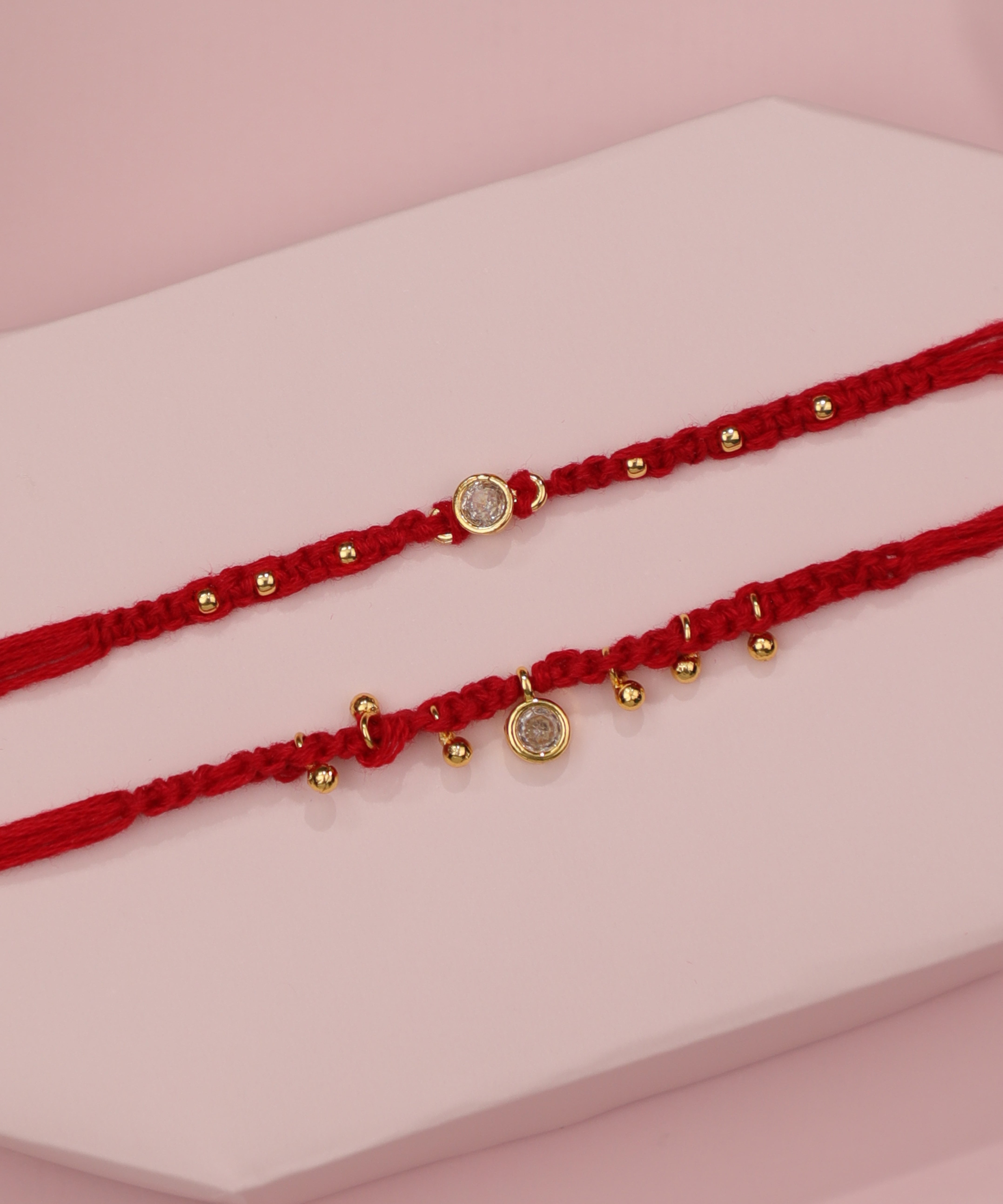 Gold-tone Rakhi set with red thread and clear CZ stones