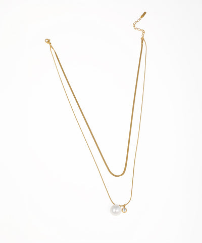 Gold-tone layered necklace with snake chain and faux pearl and CZ charms
