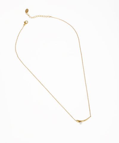 Gold-tone necklace with a curved bar pendant and small clear stone detail