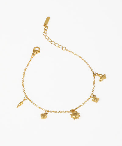 Gold-tone charm bracelet with small heart, sun, star, and abstract dangle motifs on a delicate chain