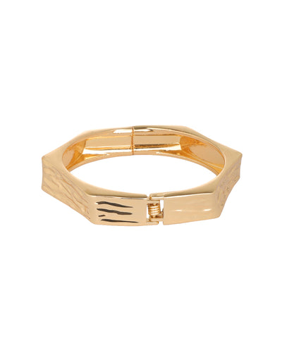 A gold-toned geometric bangle bracelet with a textured panel and a sliding clasp, shown on a plain white background.