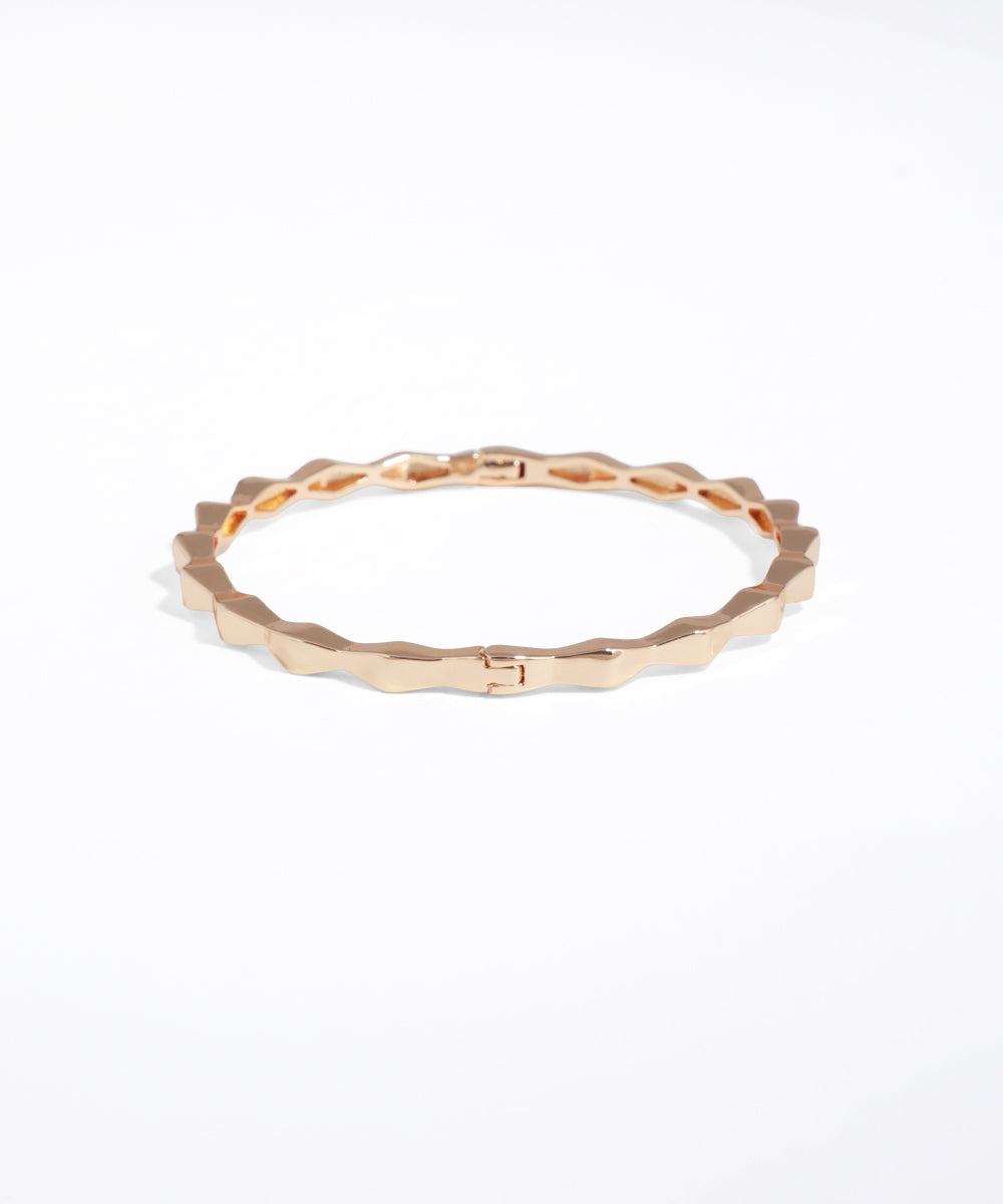 Gold ring with a textured band on a white background