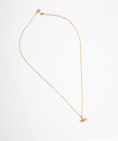 Gold-tone necklace with a small bird-shaped pendant featuring a clear stone accent on a thin chain.