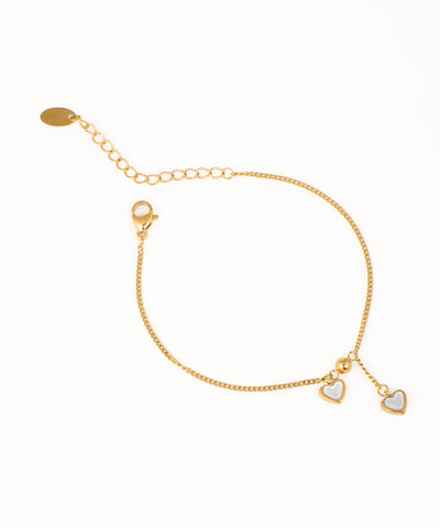 Gold-tone chain bracelet with small white heart charms and adjustable slide closure