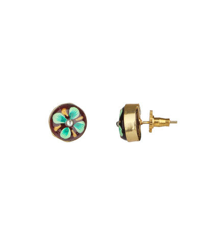 A pair of gold stud earrings featuring a circular enamel flower design with turquoise, green, and white petals on a dark brown background, shown from both front and side angles against a plain white background.