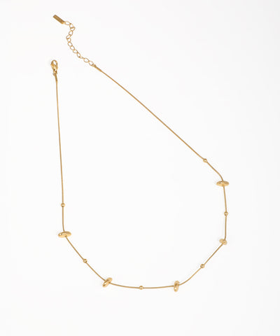 Gold-tone necklace with spaced smooth organic beads and small round accents