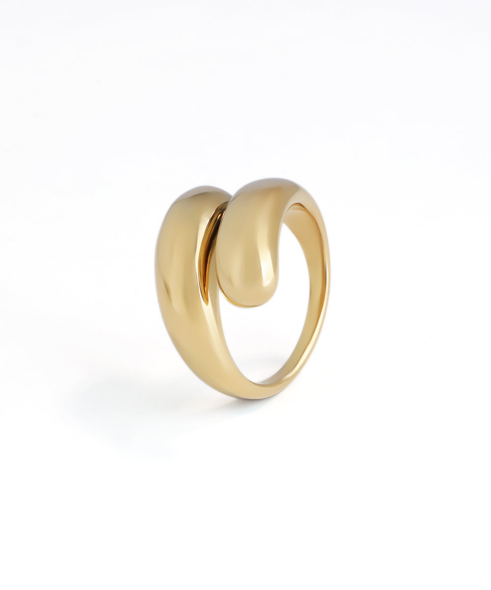 Polished gold-tone ring with a bold, fluid sculptural contour design