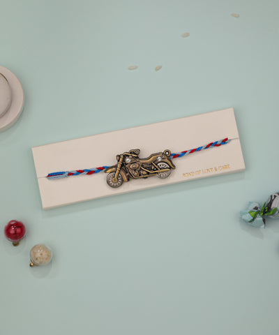 Antique gold-tone Rakhi with motorbike charm and clear stones