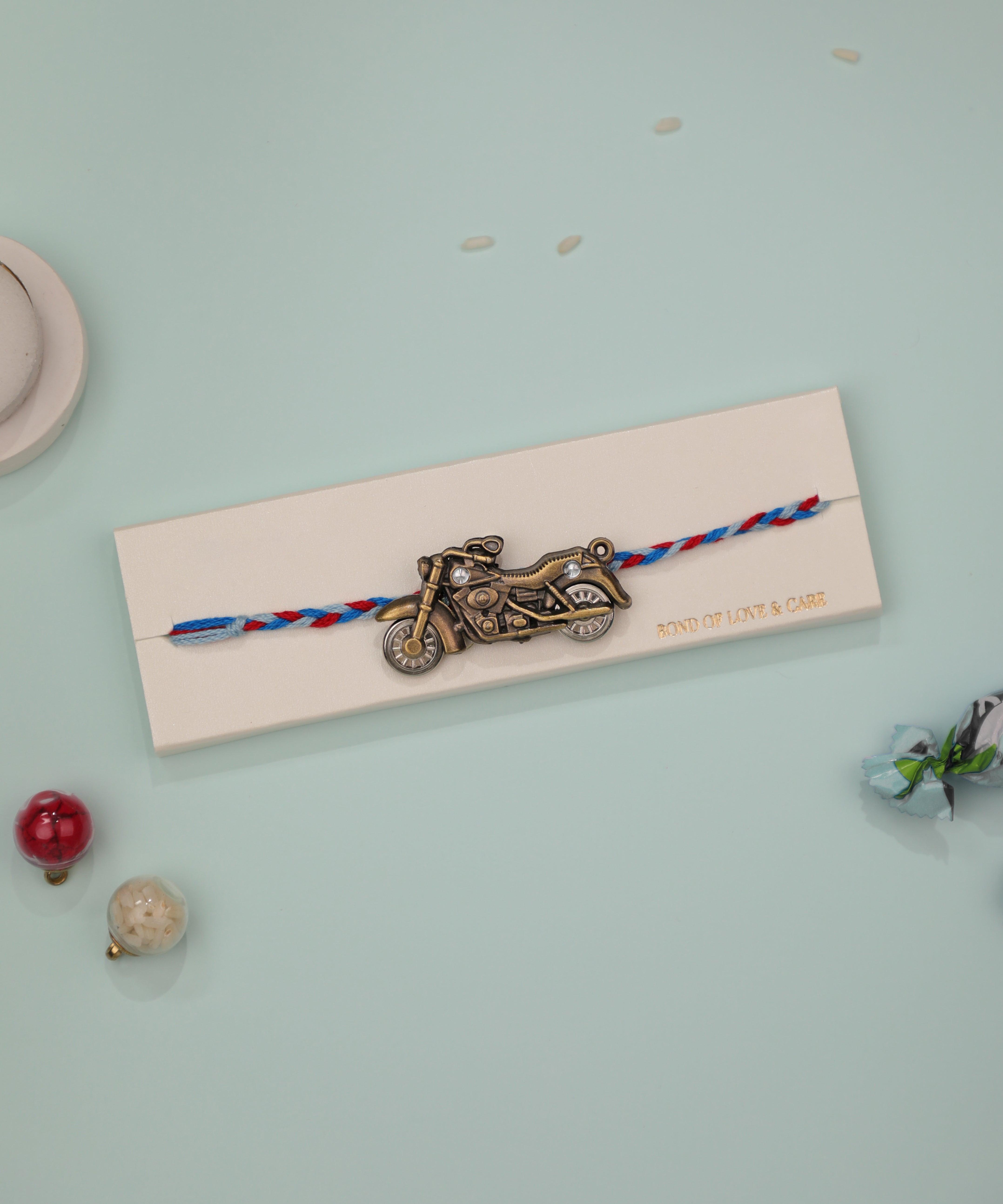 Antique gold-tone Rakhi with motorbike charm and clear stones