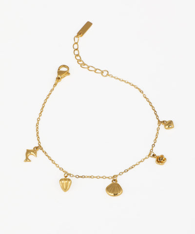 Gold-tone bracelet with multiple nature and ocean-inspired charms like a dolphin, shell, and rose.