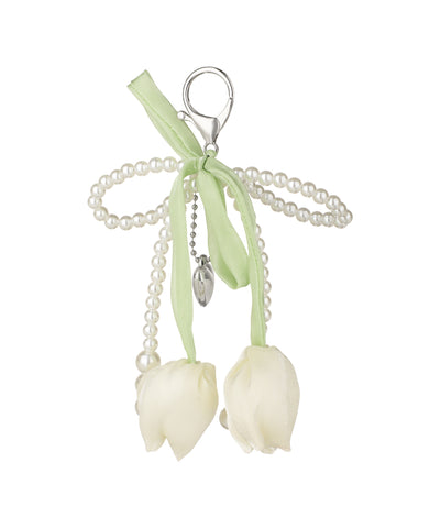 Silver-tone bag charm with faux pearl strands, green ribbon, and white fabric tulips