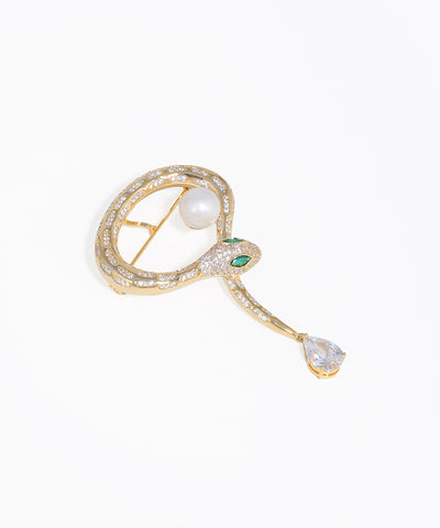Gold-tone serpent broach with sparkling clear and green stones, a faux pearl, and a pear-shaped drop.