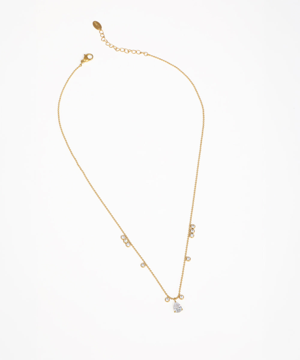 Gold-tone necklace with scattered clear round stones and a pear-shaped drop pendant