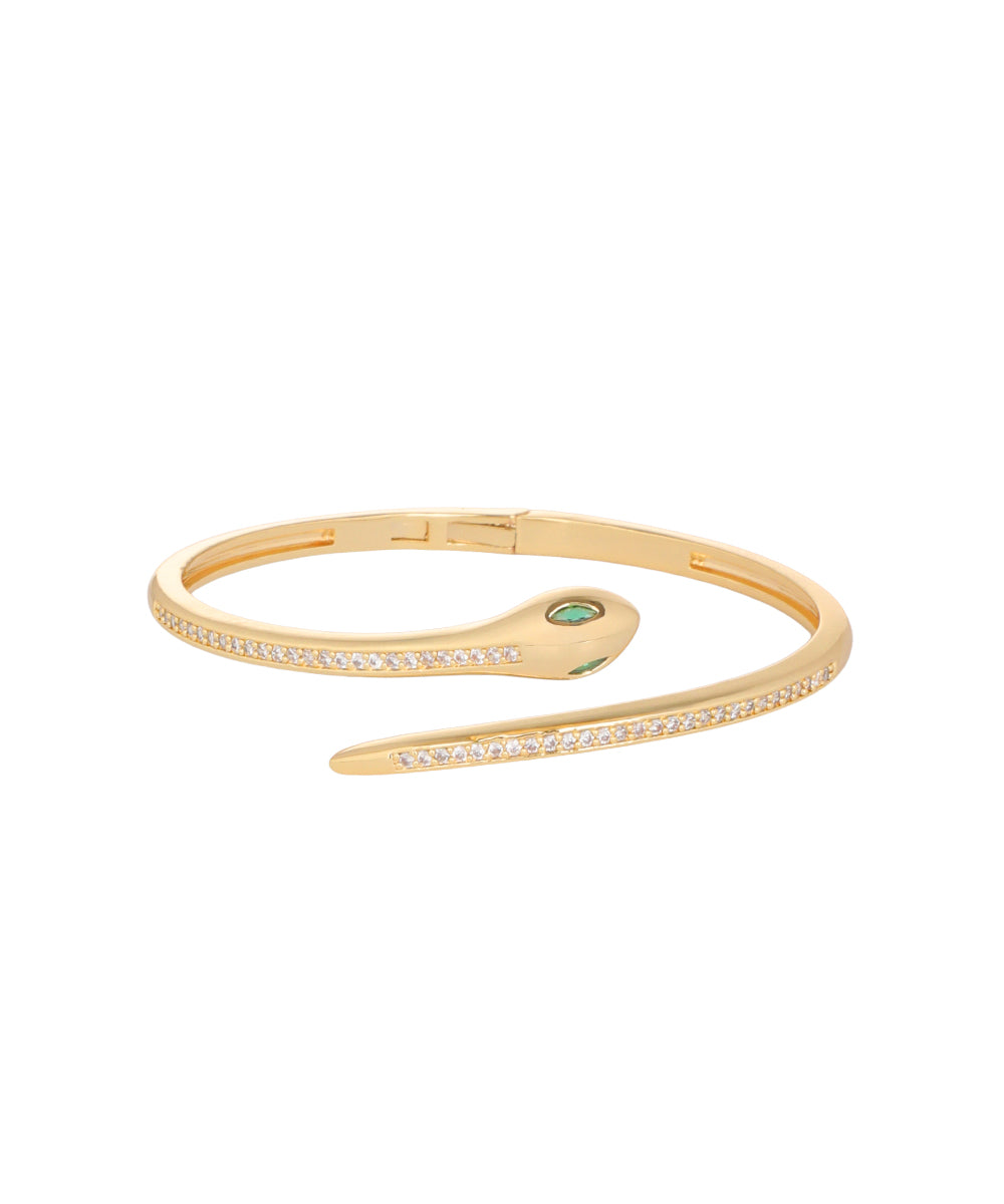A gold hinged bangle bracelet featuring a central oval bezel-set green emerald and rows of small clear stones along the outer edges, shown on a plain white background.