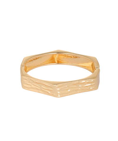 A gold hexagonal ring with a textured, wavy pattern on the outer band and a smooth, polished finish on the inner band, shown against a plain white background.