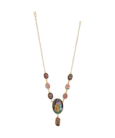 A gold chain necklace featuring a central oval pendant and a dangling charm, both decorated with colorful floral and botanical patterns, accented by small oval and round beads on either side of the chain.